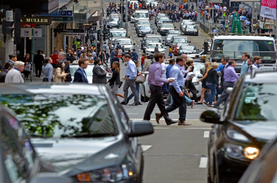 Busy traffic of many people and vehicles in Sydney downtown. As at June 2015 Sydney's estimated population was 5.05 million.